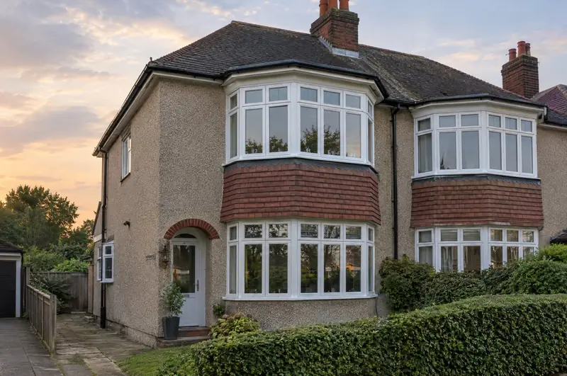 1930s semi-detached house with white two-storey bay windows