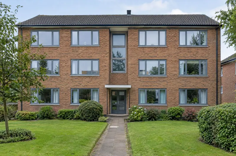 Three-storey brick apartment block with uniform new grey windows